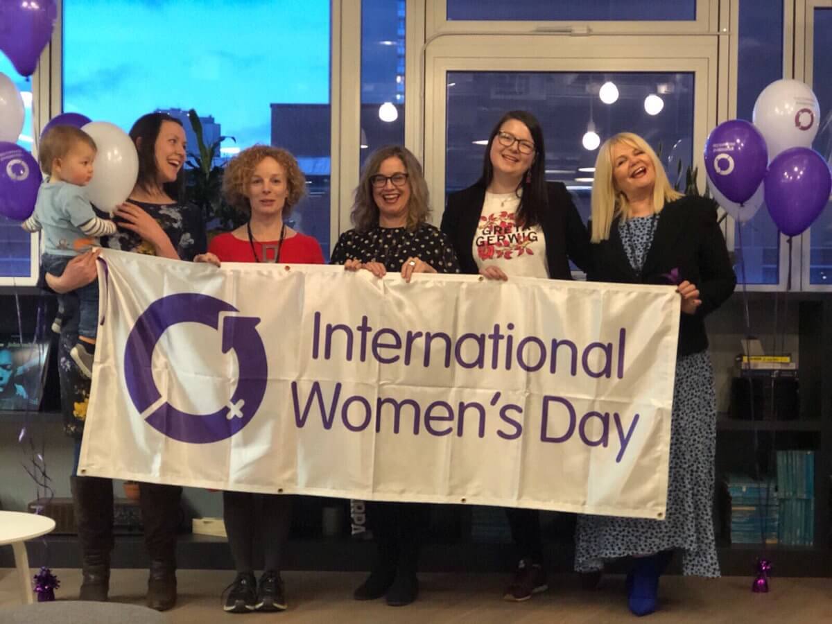 TRC Team holding a banner saying "International Women's Day"