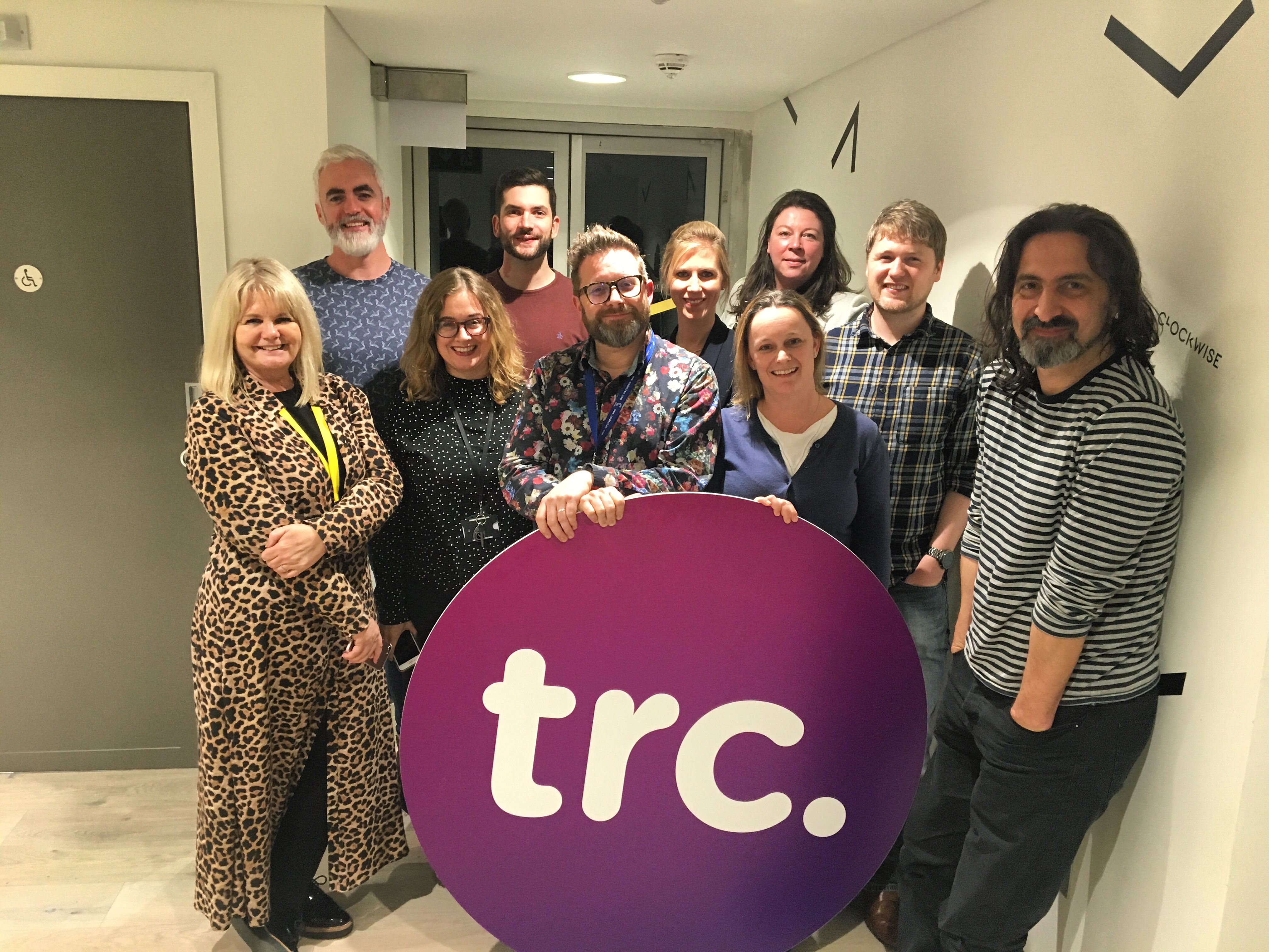 Group of Cross Creative delegates and TRC Managing Directors with TRC logo. 